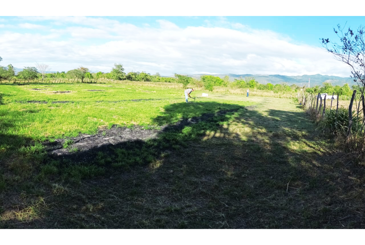 Terreno amplio en la ciudad del Zamorano con cerco perimetral, al fondo un hombre campesino labrando la tierra.