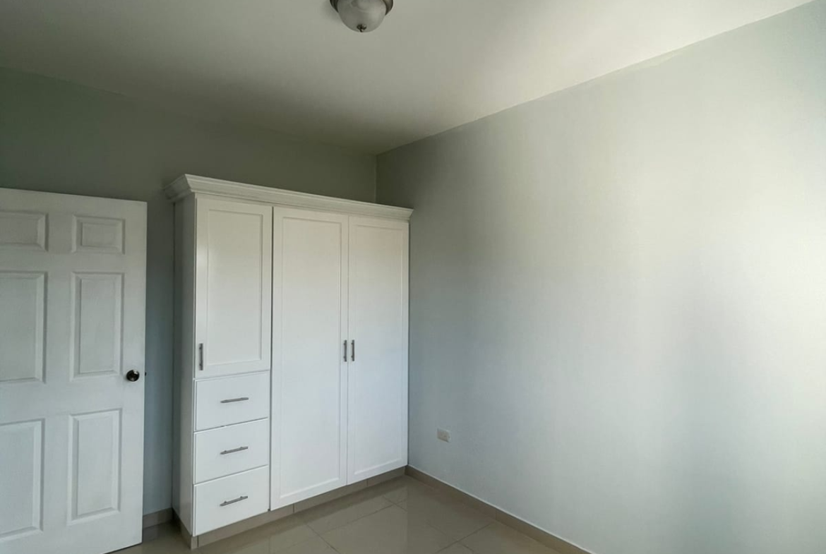 Habitación con piso porcelanato, techo tabla yeso, closet de madera color blanco.