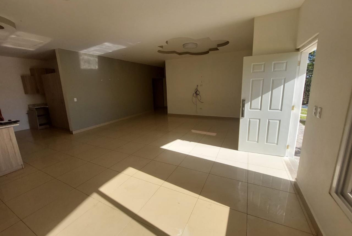 Sala amplia con piso de porcelanato, tabla yeso color blanco, con acceso a la cocina y una puerta al otro lado donde se encuentra el patio.