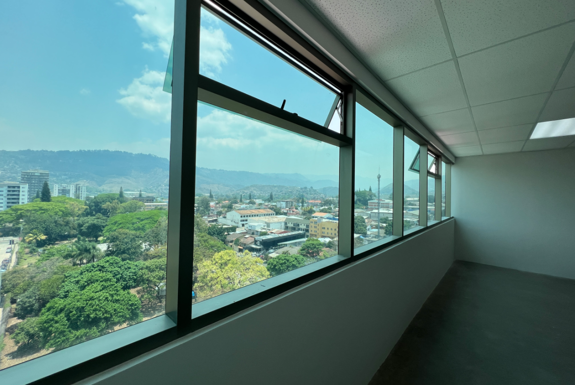 Ventana de vidrio larga horizontal con vista de día a la ciudad de Tegucigalpa en oficina torre Agalta