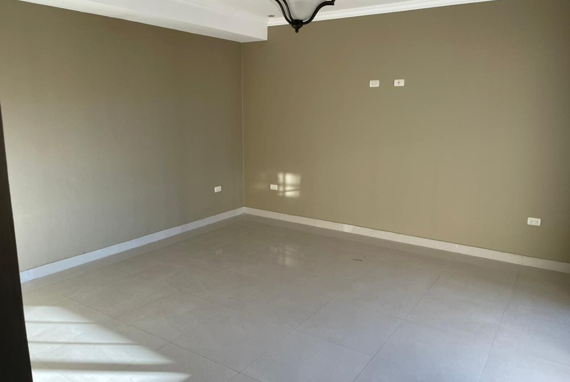 Habitación con piso porcelanato, pared color beige, techo tabla yeso y lámpara colgante.
