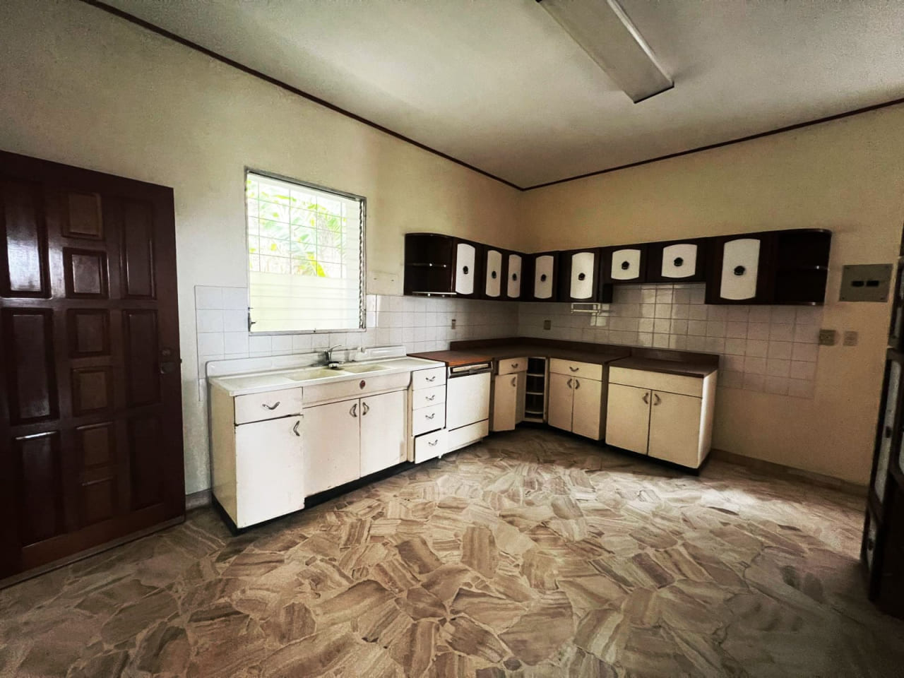Cocina con muebles color blanco y negro, piso de cerámica, techo de tabla yeso, y ventana con vista a la res. Buena Vista.