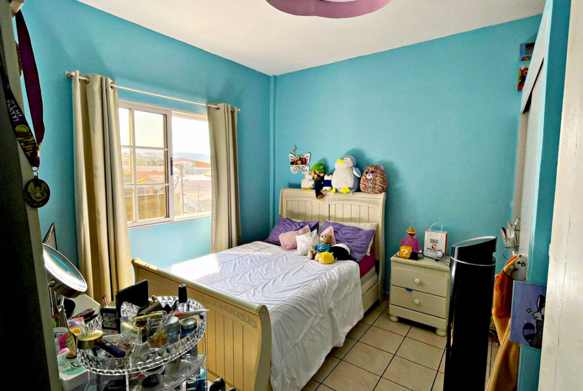 Habitación para niños o adolescentes, cuenta con área de ropero, una ventana que da al exterior y una lampara clásica en el techo que ilumina la habitación.