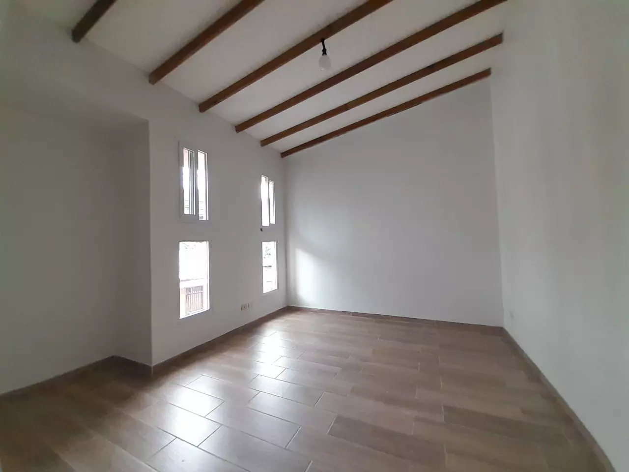 Habitación con paredes de color blanco con suelo de porcelanato estilo de madera, con ventanas corredizas de pvc.