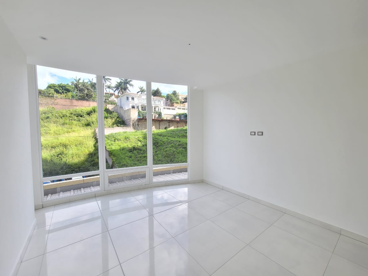 Habitación con paredes de color blanco, con suelo de porcelanat, cuenta con closet de madera clara, cuenta con un amplio ventanal y su propio aire acondicionado más su baño privado.